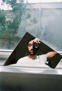 reflection of man taking pictures with camera in mirror