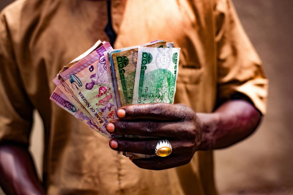 man holding nigerian currency in bida