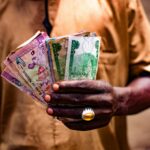 man holding nigerian currency in bida