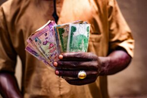 man holding nigerian currency in bida