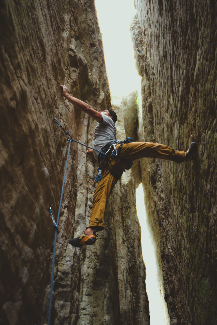 man climbing on cliff
