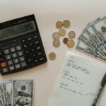 black calculator beside coins and notebook