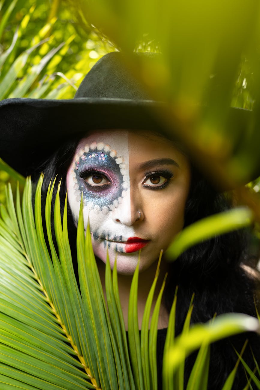 a woman with a skull face paint and a hat