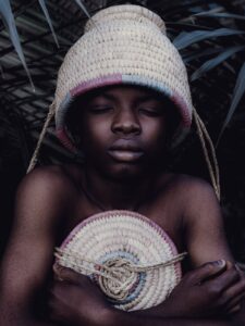 portrait of african child with woven hat in nigeria