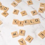 scrabble letters spelling yield on a white table