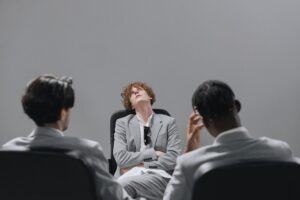 man looking up while sitting with his arms crossed