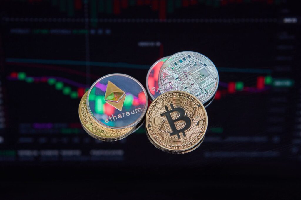 coins with cryptocurrencies symbols on the background of graphs