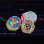 coins with cryptocurrencies symbols on the background of graphs