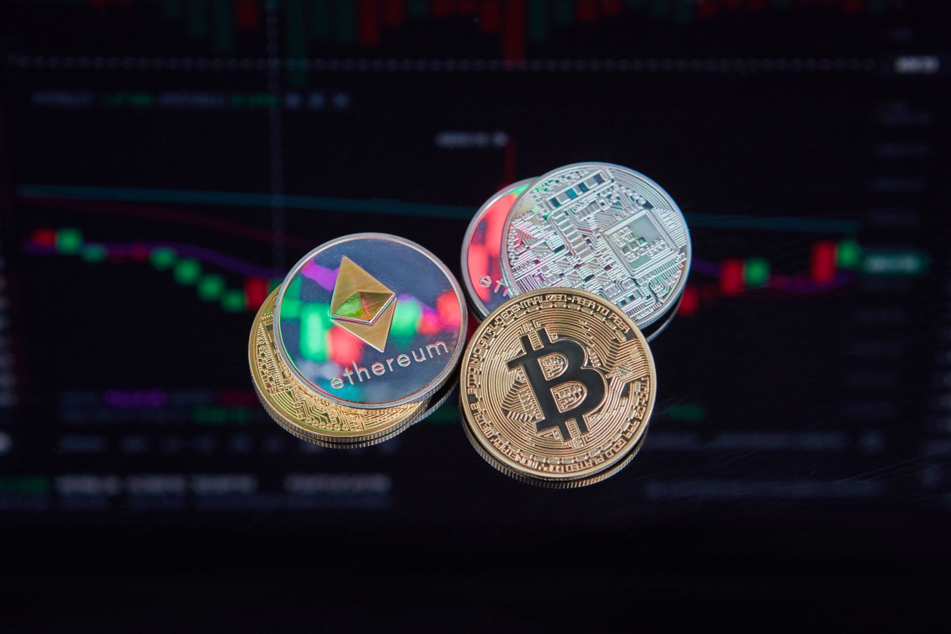 coins with cryptocurrencies symbols on the background of graphs