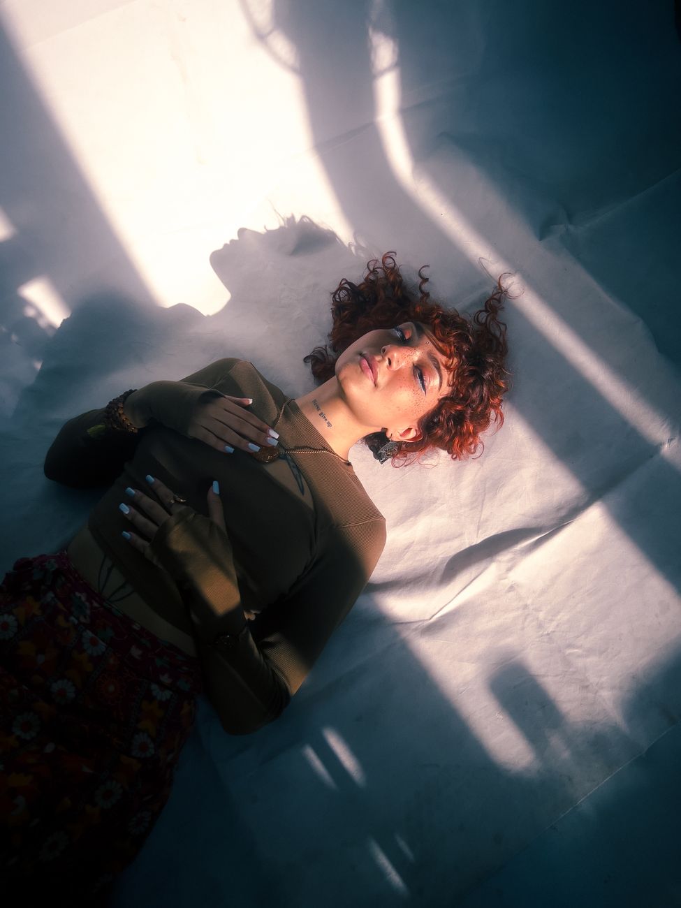 a woman laying on a bed with her head in the sun
