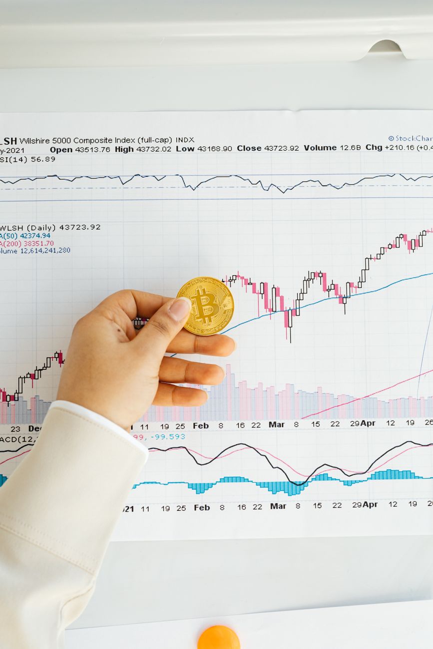a person holding gold bitcoin