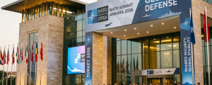 Delegates walking outside a modern building with NATO Summit Ankara 2026 banners and flags