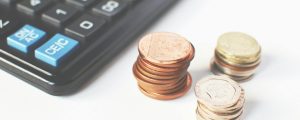 gold colored coins near calculator