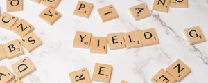 scrabble letters spelling yield on a white table