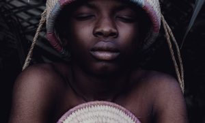 portrait of african child with woven hat in nigeria