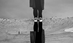 a grayscale photo of a reflection of a woman on water