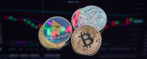 coins with cryptocurrencies symbols on the background of graphs