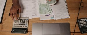 man sitting at the desk and counting money while using a calculator