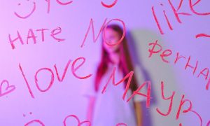 teenage girl behind glass with words